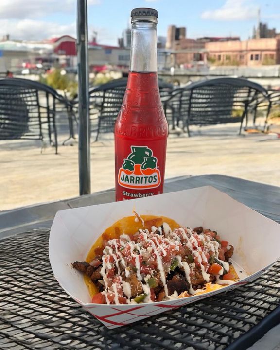 BLZN tacos and a bottled soda at an outdoor table