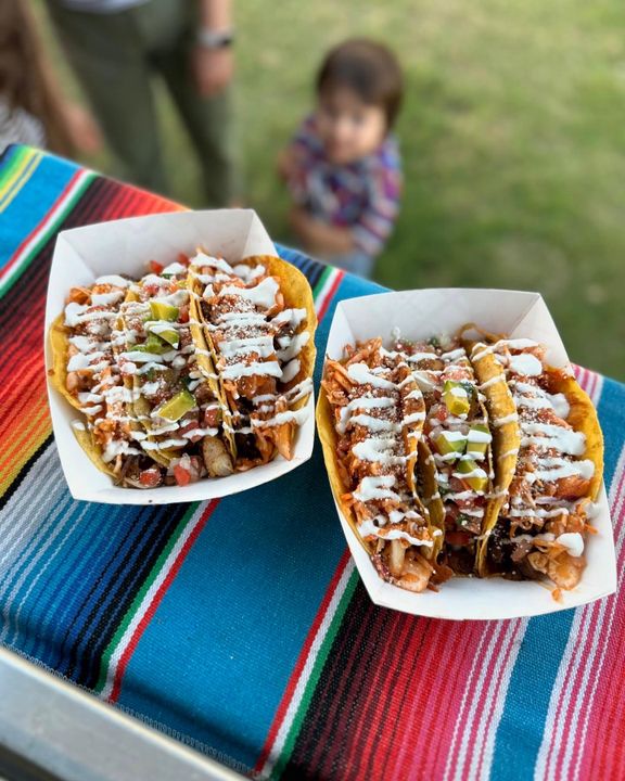 Two trays of BLZN tacos served outdoors
